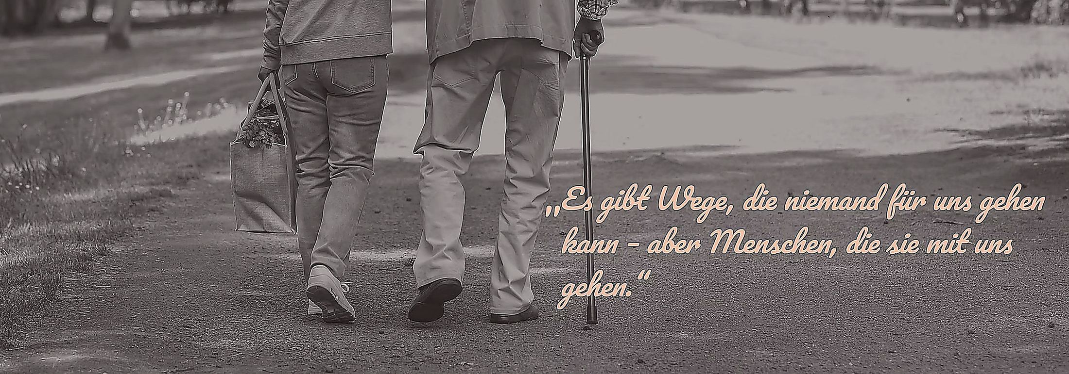 A carer accompanies an older person on a walk. Caption: There are paths no one can walk for us – but there are people who walk them with us.