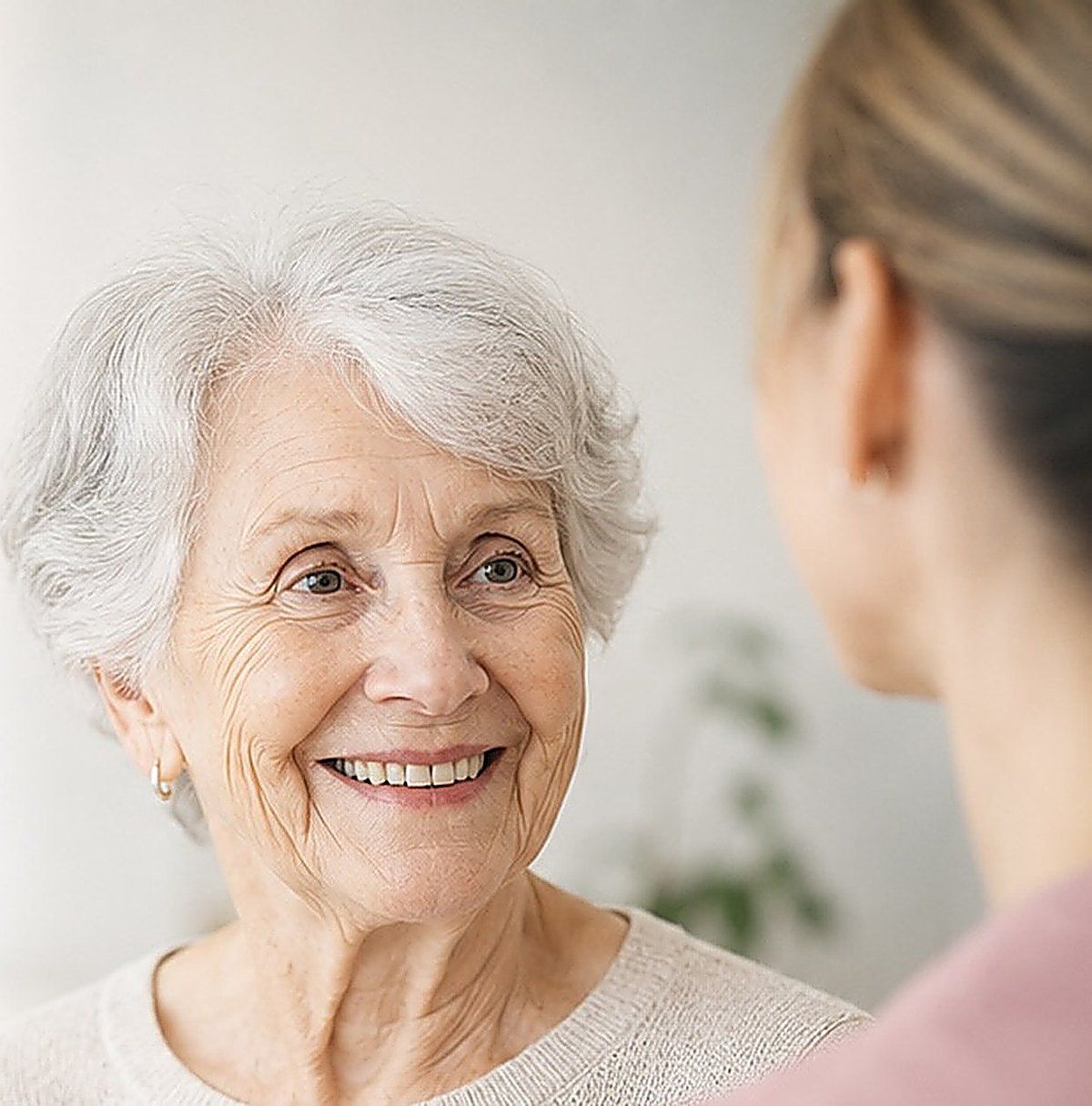 A carer talking with a smiling elderly woman