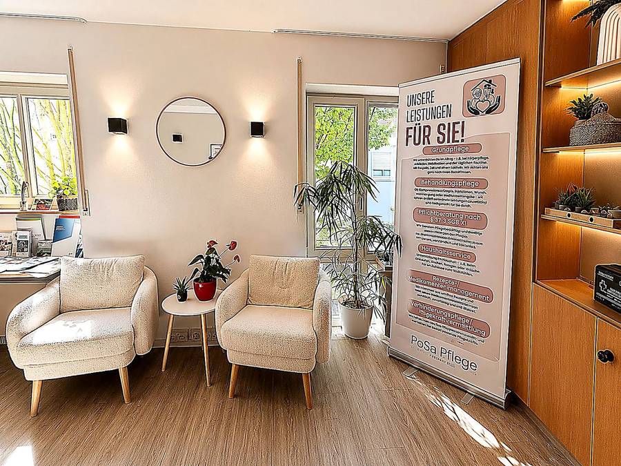Consultation corner with two armchairs, plants and an information board in the PoSa head office in Lahr